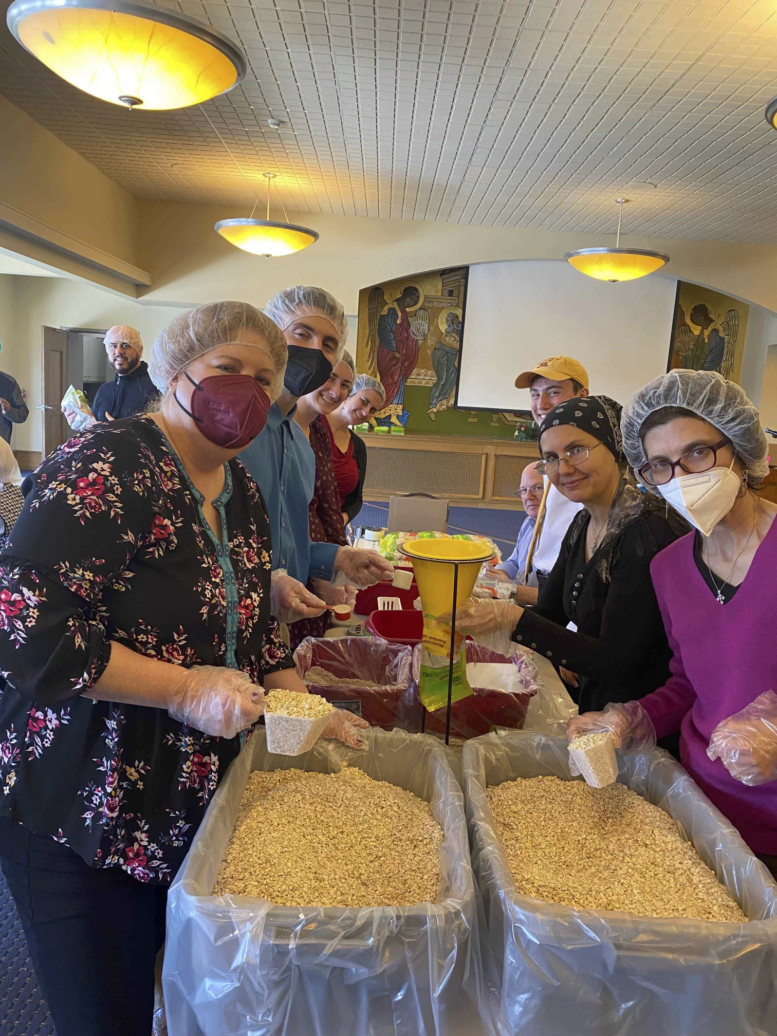 8 volunteers pictured around a table packing oatmeal.