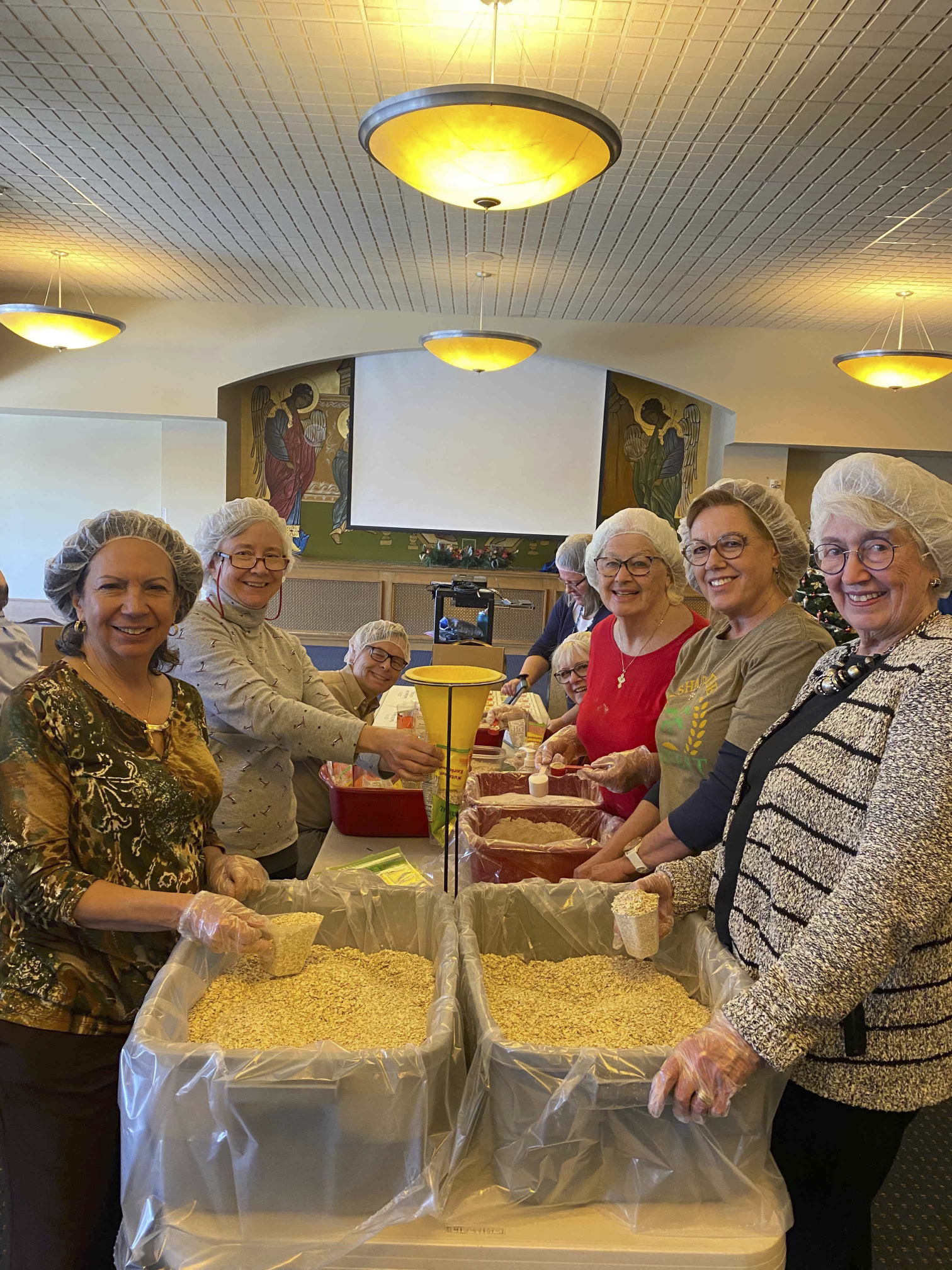 8 volunteers pictured around a table packing oatmeal.